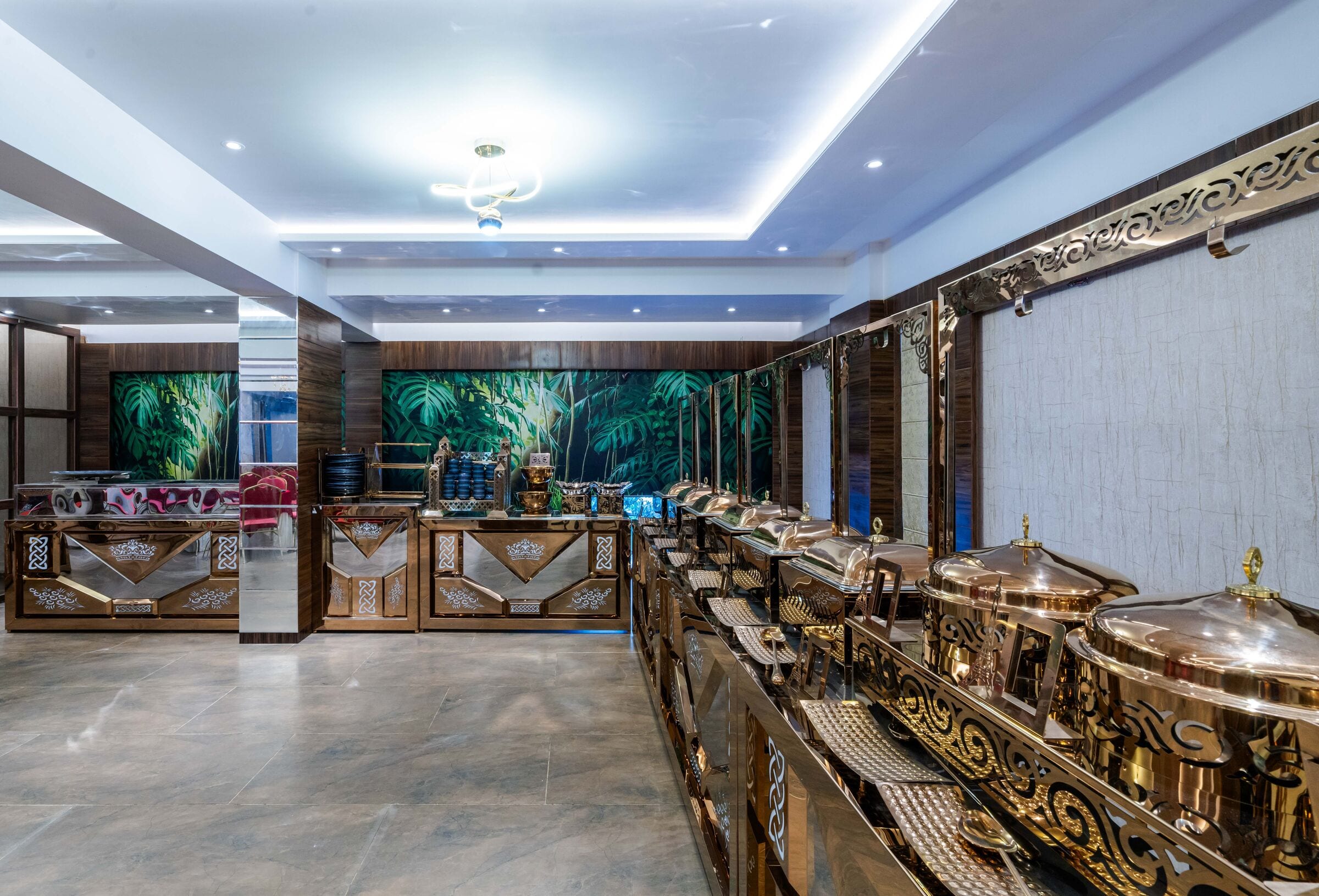 Brass buffet counters beneath a tropical leaf mural