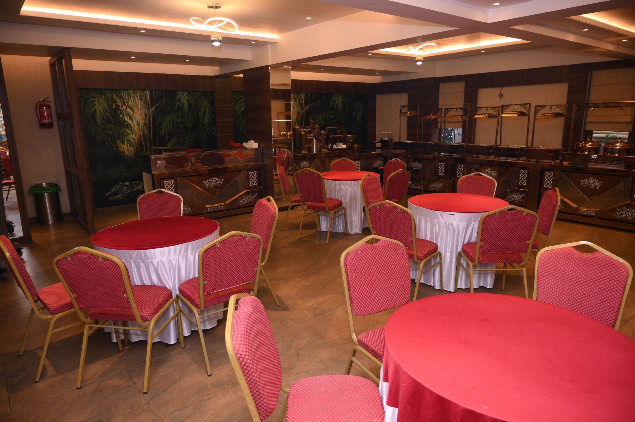 The banquet hall in warm light, round tables dressed in red and white
