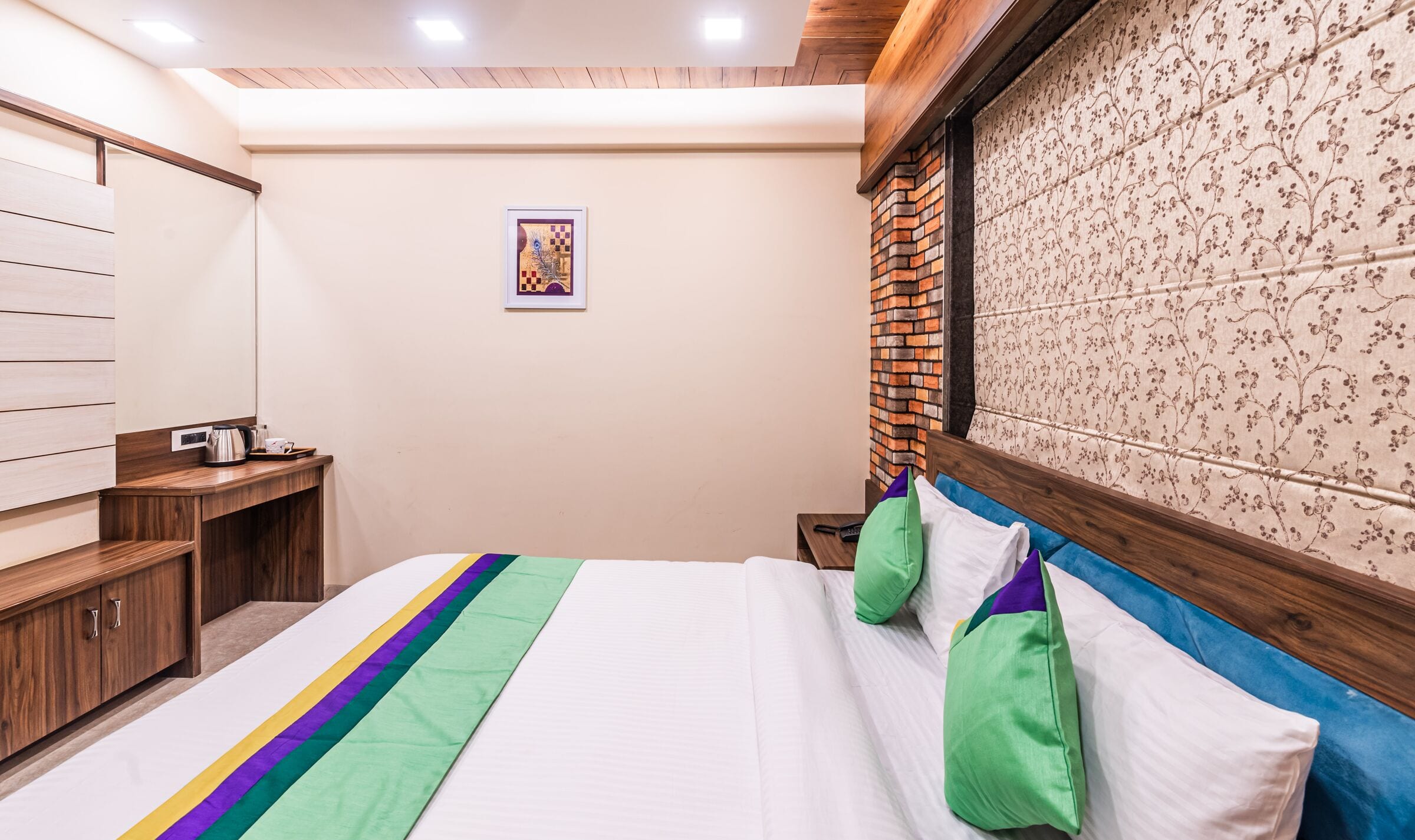 The Executive bed: exposed brick framing a floral roman blind under a wood-panelled ceiling band