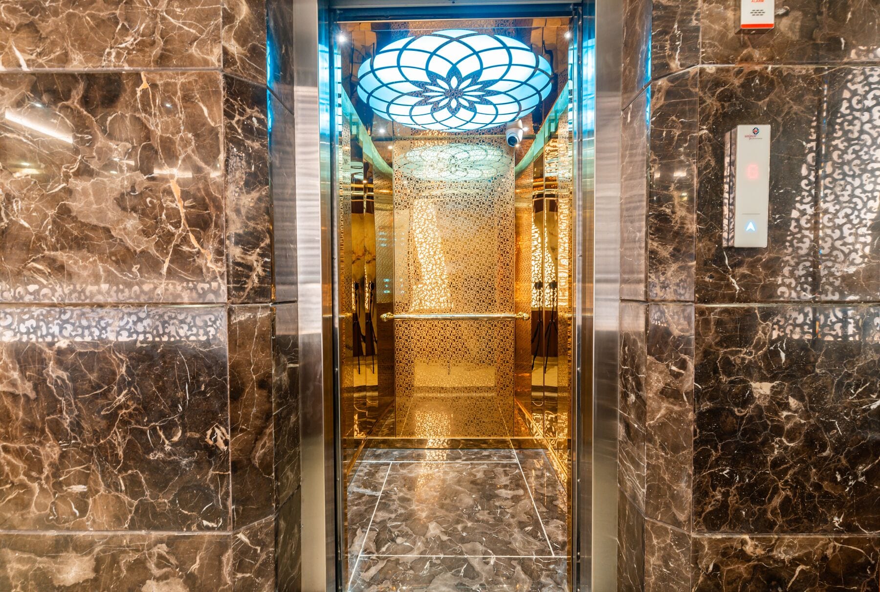 Inside the lift, the lotus ceiling lit in blue and gold