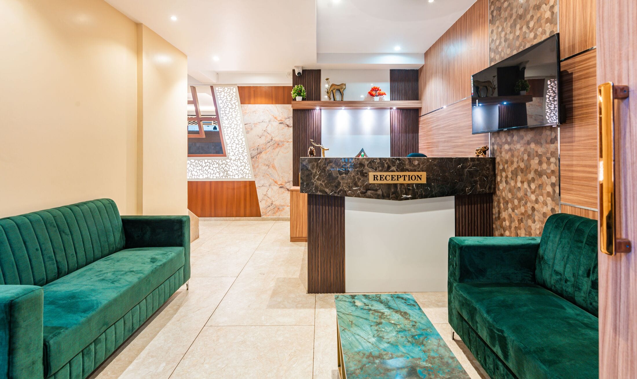 The reception desk in dark marble, framed by walnut panelling