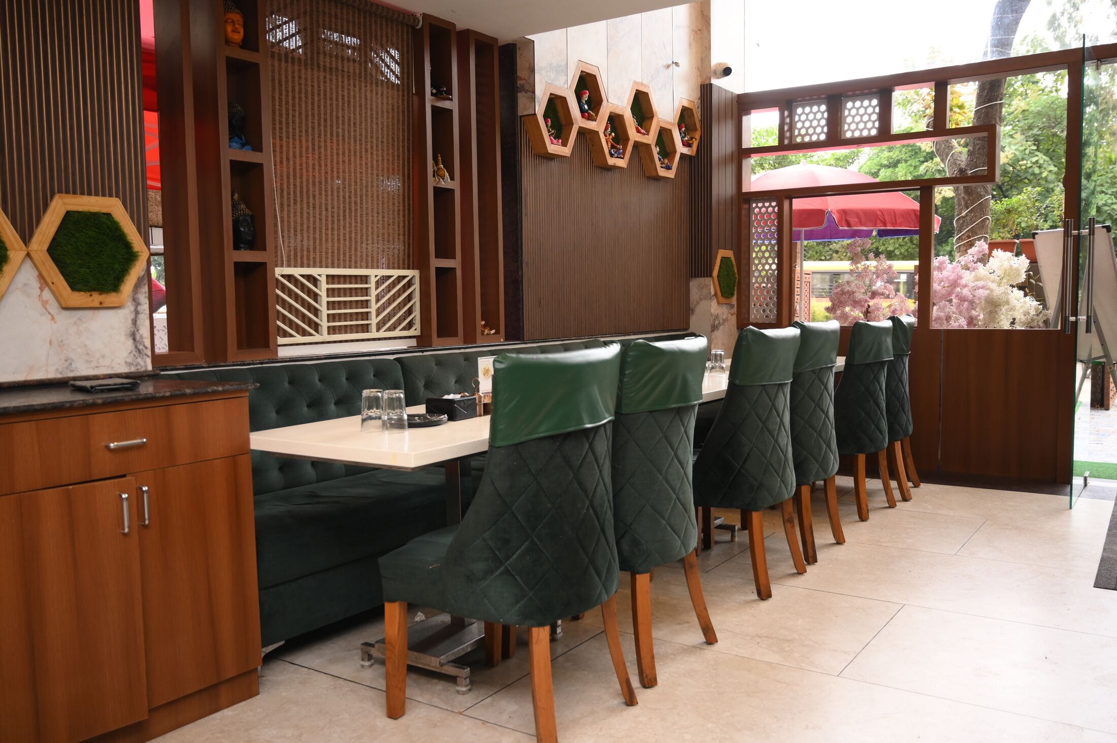 The restaurant: green quilted-leather chairs, white tables and hexagonal walnut shelving with moss panels