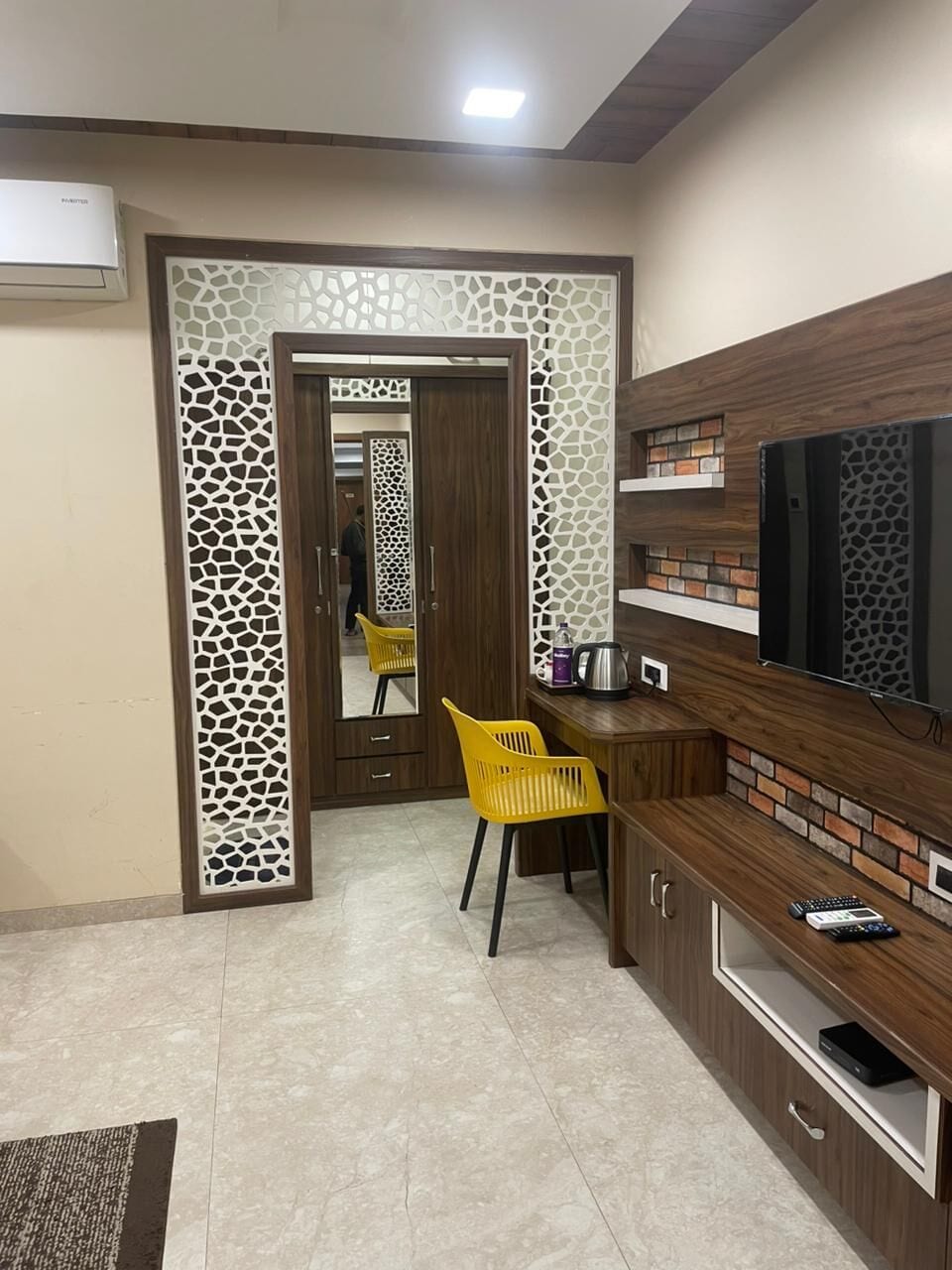 The Deluxe room's walnut TV console and desk beside the jaali-framed entry