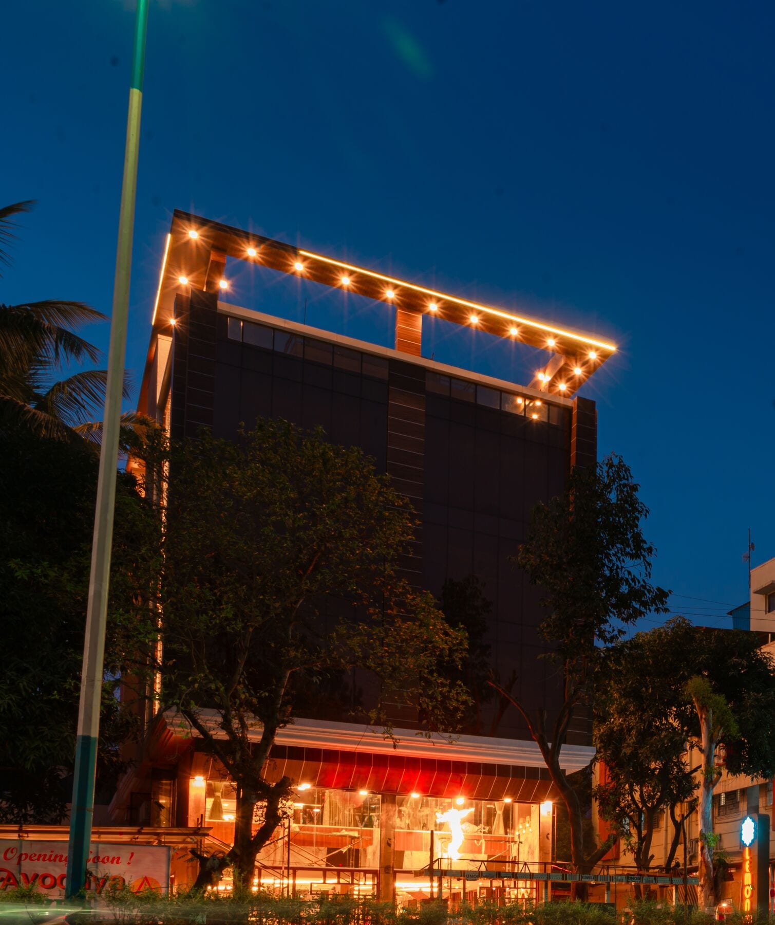 The rooftop crown lit against a deep blue evening sky
